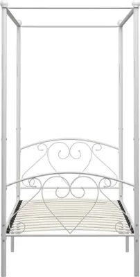A white metal canopy bed frame with heart details.