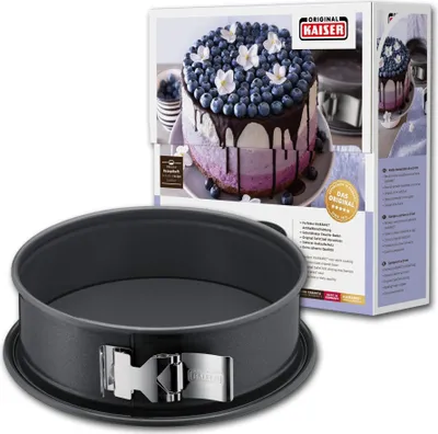 A springform pan is shown in the foreground, with its packaging in the background. The packaging displays a picture of a cake made in the pan.