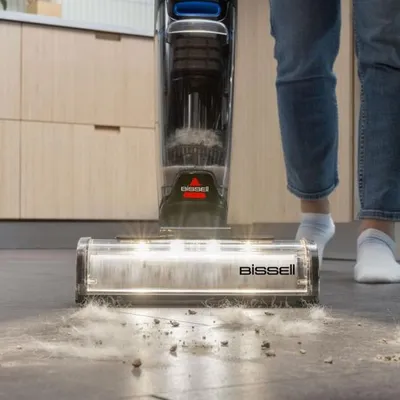 A person is using a BISSELL CrossWave OmniFind Select vacuum cleaner on a floor in a kitchen or similar room.