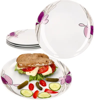 A stack of plates with a sandwich and garnishes on one plate.