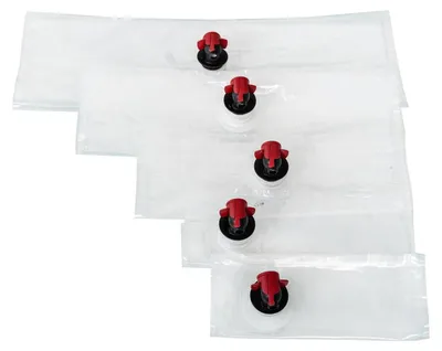 A stack of five empty bag-in-box pouches with spouts.