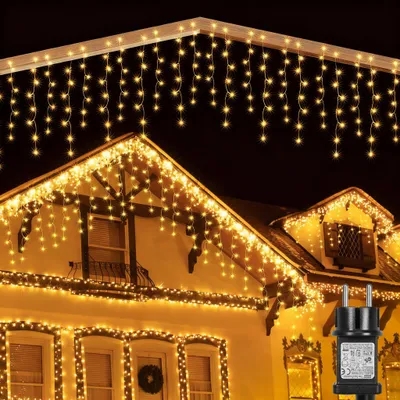A house decorated with icicle-shaped Christmas lights at night.