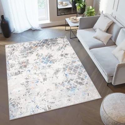 A modern living room with a rug, sofa, and ottoman.