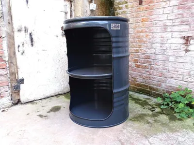 A modified oil barrel used as a shelf unit, placed outdoors next to a brick wall and a white door.