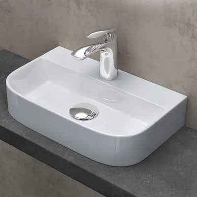 A white ceramic sink with a chrome faucet sits on a dark gray countertop.