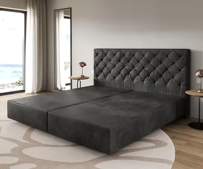 A bed frame with a tufted headboard in a bedroom setting.