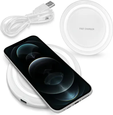 A smartphone is placed on a wireless charging pad, with a USB cable nearby.