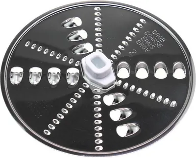 A close-up, top-down view of a food processor disc with various grating and slicing blades.
