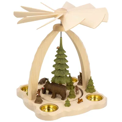 Ein hölzernes Weihnachtspyramidenmodell zeigt eine Szene mit einem großen Bären und mehreren kleineren Tieren sowie Figuren um einen zentralen Baum herum während oben Flügelblätter angebracht sind die sich durch aufsteigende Wärme drehen