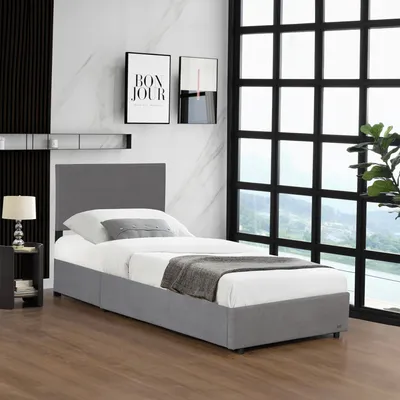 A single bed with a headboard and storage drawers, set in a modern bedroom with a large window overlooking a landscape.