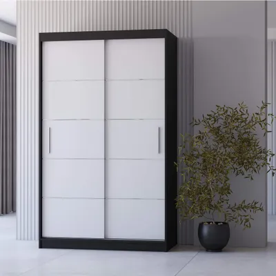 A modern wardrobe with sliding doors in a room with minimalist decor.