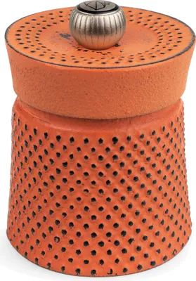 A close-up studio shot of an orange pepper mill.