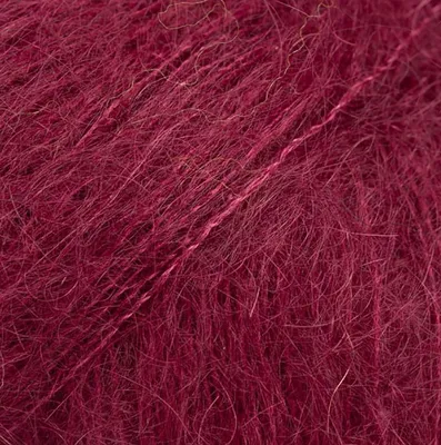 A close-up, textured view of burgundy yarn.