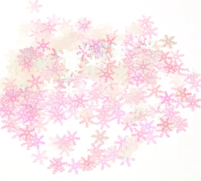 A pile of iridescent pink snowflake confetti scattered on a white background.