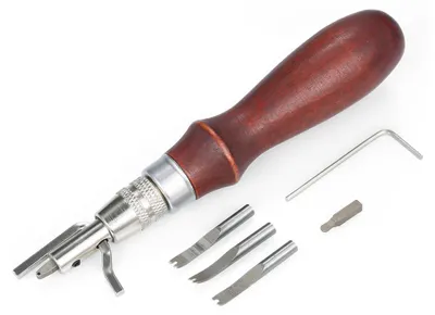 A leatherworking tool set with a wooden handle and interchangeable steel blades, along with an Allen wrench and a bit, laid out on a white background.