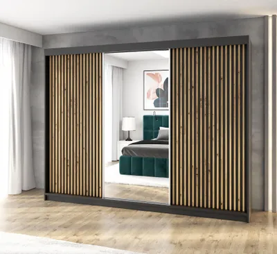 A modern wardrobe with a mirrored door, reflecting a bedroom scene with a bed.