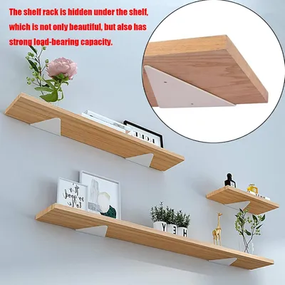 Three wooden shelves are mounted on a light gray wall, with various decorative items and books placed on them. A close-up inset shows a white triangular bracket supporting a shelf.