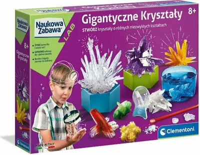 The image shows the packaging of a science kit for making giant crystals. A boy is looking at a magnifying glass, and various crystal formations are displayed on the box.