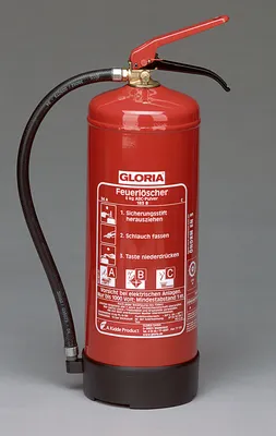 A red fire extinguisher with a black hose and base, set against a plain gray background.