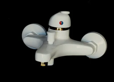 A white and gold bathtub faucet against a black background.