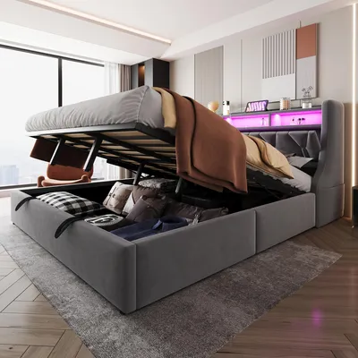 A bedroom with a large storage bed with its lift-up mechanism open, revealing stored items. The bed has LED lighting.