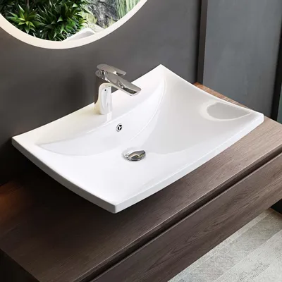 A white ceramic sink with a chrome faucet is shown on a dark wood vanity.