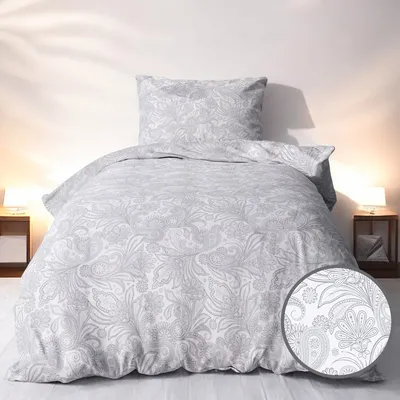 A neatly made bed with a duvet and pillow, featuring a floral pattern.