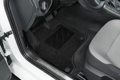 Interior view of a car, focusing on the driver's side floor mats.