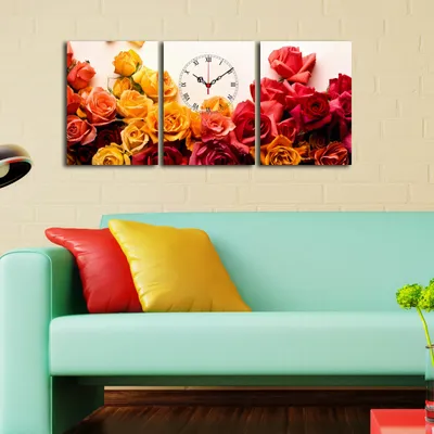 A triptych wall clock featuring roses is displayed above a sofa with colorful pillows.