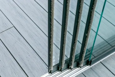A close-up view of a sliding glass door with aluminum brush seals.