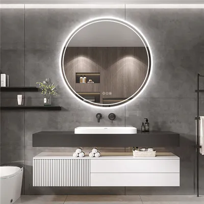 A modern bathroom vanity with a round LED mirror above a sink and cabinet.
