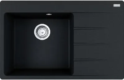 A top-down view of a black kitchen sink with a silver drain.
