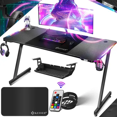 A gaming desk setup with various accessories, illuminated by LED lights.