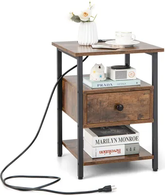 A small wooden side table with a drawer and shelves, decorated with a vase of flowers, a cup, and books.