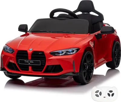 A red electric toy car, a replica of a BMW M4 Competition, is shown from a front-diagonal angle on a white background. A white remote control is visible in the lower right corner.