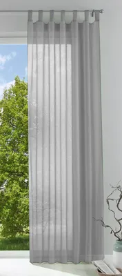 A sheer gray curtain hangs in front of a window with trees visible outside.