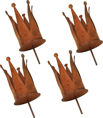 Four rusty metal crown-shaped candle holders arranged diagonally on a white background.