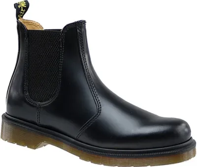 A black Dr. Martens Chelsea boot is shown against a white background.