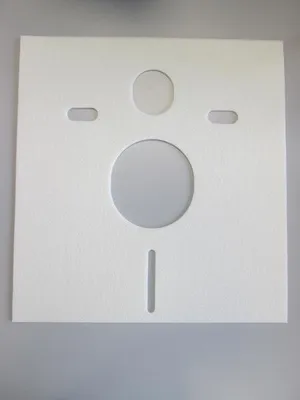 A white square gasket with several cutouts, likely for plumbing.