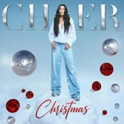 A woman stands on a snowy surface with Christmas ornaments scattered around her. The word 'Christmas' is written in cursive below her.