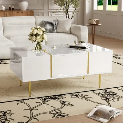 A modern living room scene with a white couch and a white coffee table with gold accents.