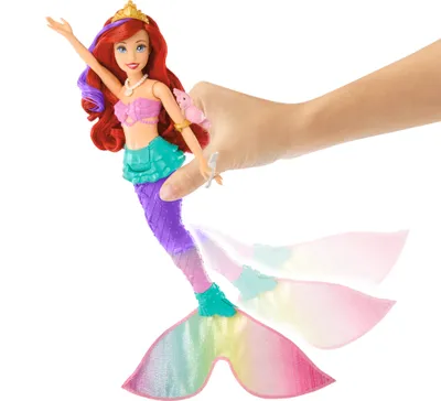 Ariel mermaid doll with a hand holding it.