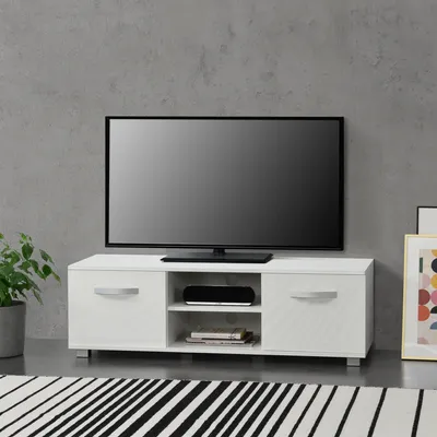 A white TV stand with a television on top, placed against a gray concrete wall.