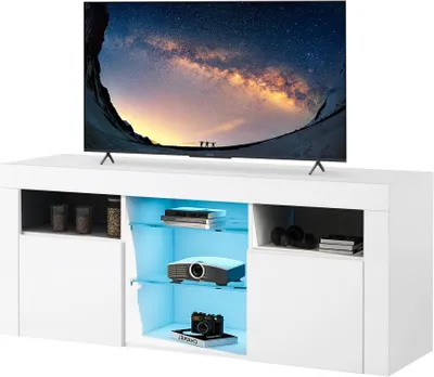 A white TV stand with a television on top and various items displayed on its shelves, including a projector and camera.
