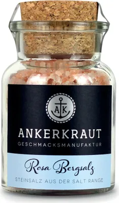 A glass jar of pink Himalayan salt with a cork lid and a label.