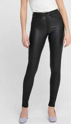 A person wearing black skinny jeans and light purple shoes against a white background.