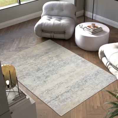 A rug is placed on a wooden floor in a living room setting with furniture.