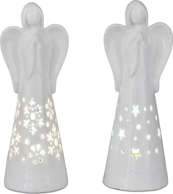 Two white ceramic angel figurines with cut-out designs illuminated from within.