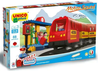 The image shows the packaging of a toy train set, depicting the assembled toy with a train, station, and figures.