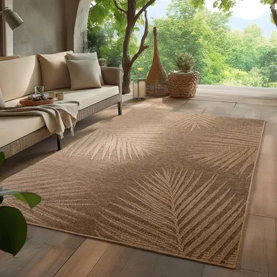 An outdoor living space with a sofa and a rug on a wooden deck, surrounded by greenery.